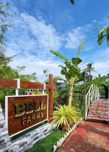 a sign for a hotel with a wooden fence at Bell Farms and Resorts in Munroe Island