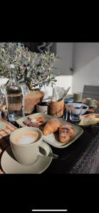 una mesa con una taza de café y un plato de comida en I SECOLARI en Sannicandro di Bari