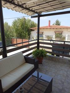 patio con sofá y banco en el balcón en Johnny 's private house, en Pálioura