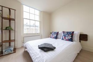 a bedroom with a large white bed with blue pillows at The CoDalston in London