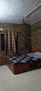 Tulsi Paradise Resort في Nirmal: سرير صغير في غرفة بها جدار