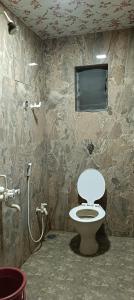 een badkamer met een toilet en een douche bij Tulsi Paradise Resort in Nirmal