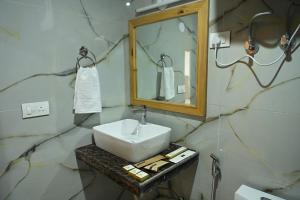 a bathroom with a sink and a mirror at Hotel Nirvana Hills With Balcony Rooms And Open Terrace in Manāli
