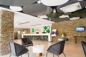 a lobby of a store with chairs and a tv at Go Hotels Bacolod in Bacolod