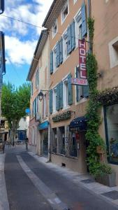 a building with a sign on the side of a street at Hôtel Saint Florent in Orange