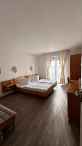 ein Schlafzimmer mit einem großen Bett und einem großen Fenster in der Unterkunft Hotel Hirschberg in Hirschberg an der Bergstraße