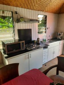 a kitchen with a microwave and a stove top oven at Orchid Island one bedroom Bure in Pacific Harbour