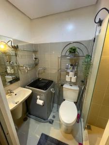La salle de bains est pourvue de toilettes et d'un lavabo. dans l'établissement Luminette Properties, à Manille