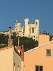 un gran edificio blanco en la cima de una colina en Le Secret des Templiers en Lyon