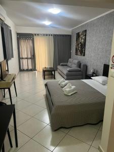 uma sala de estar com uma cama e um sofá em AVR Airport Deluxe Suites 4 em Markopoulo Mesogaias