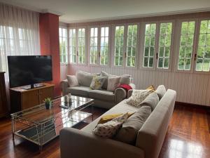 a living room with couches and a flat screen tv at La Costana - San Cucao de Llanera in Agüera
