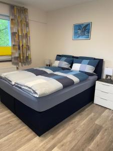 sypialnia z dużym łóżkiem w kolorze niebieskim i białym w obiekcie Boarding House Zweibrücken w mieście Zweibrücken