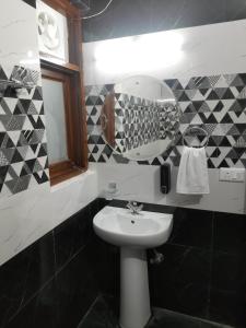 a bathroom with a sink and a mirror at Aagaman Woods Homestay in Shimla