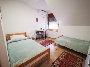 a bedroom with two beds and a table in it at Šljivik stari in Brestovac +29 photos