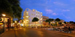 a large white building on a city street at night at Hotel Al Cavallino Bianco in Riccione