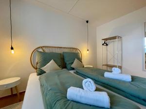 una camera con due letti verdi con asciugamani di Bamboo Village a Magdeburgo