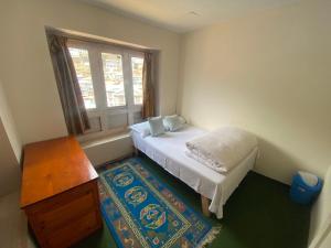 Habitación pequeña con cama y ventana en Himalayan Lodge en Nāmche Bāzār