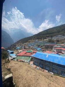 uma vista para uma cidade com edifícios e montanhas em Himalayan Lodge em Nāmche Bāzār