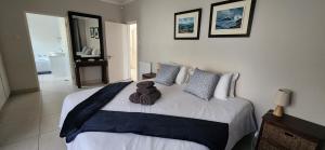 a teddy bear sitting on a bed in a bedroom at Picollo Bocca Villa Kleinmond in Kleinmond