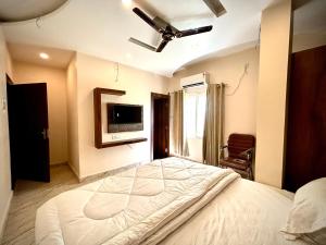 a bedroom with a large bed and a ceiling fan at HOTEL VIA GANGA INN ! VARANASI ! FULLY AIR-CONDITIONED HOTEL AT PRIME LOCATION WITH ROOFTOP GANGES VIEW! 2 Min walking distance from ASSI GHAT ,NEAR KASHI VISHWANATH TEMPLE in Varanasi