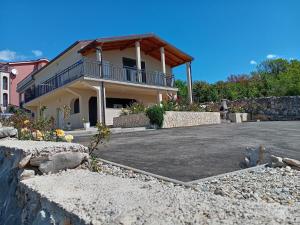 a house with a parking lot in front of it at Apartmani Suzana in Crikvenica