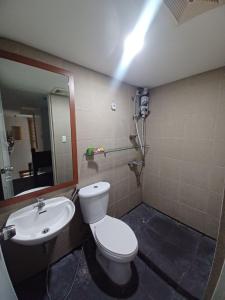 a bathroom with a white toilet and a sink at ADB Tower - Loft Unit Hotel Vibe in Manila