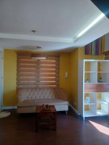 ein Wohnzimmer mit einem Sofa und einem Tisch in der Unterkunft ADB Tower - Loft Unit Hotel Vibe in Manila