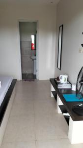 a bedroom with a desk and a bed and a bathroom at G Hotel in Dauis