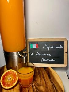 a juicer and a glass of orange juice on a cutting board at B&B Casa Wanda since 1999 in Riva del Garda