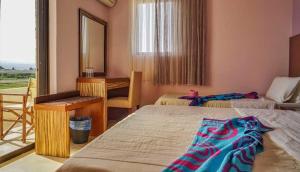 um quarto com 2 camas, uma secretária e um espelho. em GOLDEN SUN em Vrachati