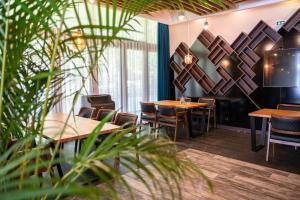 um restaurante com mesas de madeira, cadeiras e plantas em PARK Hotel & SPA Jablanica em Jablanica