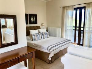 a bedroom with a bed and a mirror at Elaion mini suites in Nafplio