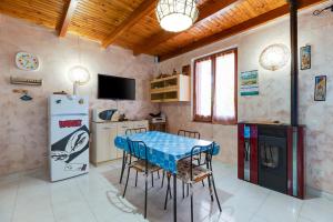 eine Küche mit einem Tisch und einem Kühlschrank in der Unterkunft Home Holidays Pintadera 1 in Bosa
