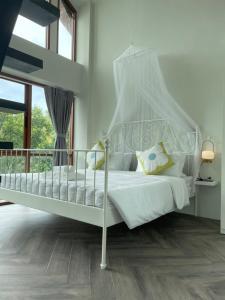 een wit bed met een baldakijn in een slaapkamer bij Vana Kiri Land in Ban Thung Sam Sao