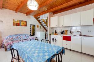 eine Küche mit einem Bett und einem Tisch in einem Zimmer in der Unterkunft Home Holidays Pintadera 1 in Bosa