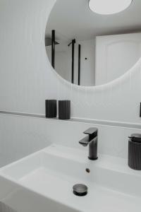 een witte badkamer met een wastafel en een spiegel bij sleepArt Black&White in Celle
