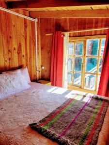 sypialnia z dużym łóżkiem i oknem w obiekcie Alojamientos La Casita del Centro w mieście Panguipulli