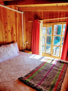 a bedroom with a large bed with a window at Alojamientos La Casita del Centro in Panguipulli