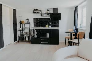 a kitchen with black and white appliances and a living room at sleepArt Black&White in Celle