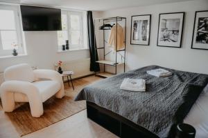 een slaapkamer met een bed en een witte stoel bij sleepArt Black&White in Celle