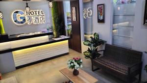 a lobby of a hotel with a bench and flowers at G Hotel in Dauis