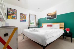 een slaapkamer met een groot bed met een groene muur bij GuestReady - Artsy Penthouse in Heart of the City in Londen