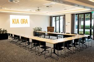 une grande salle de conférence avec une grande table et des chaises dans l'établissement Sudima Kaikōura, à Kaikoura