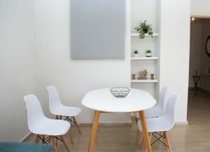 a white table and four white chairs in a room at Nafplio Relax Retreat in Nafplio