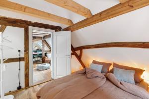 ein Schlafzimmer mit einem großen Bett und einem Spiegel in der Unterkunft Das Alte Pfarrhaus Galerie in Gleisweiler