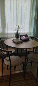laptopa siedzącego na drewnianym stole z krzesłami w obiekcie Spokojne i miłe miejsce na Mazurach w mieście Kętrzyn