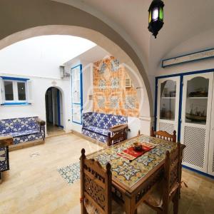 un soggiorno con tavolo e divano di medina hammamet a Hammamet