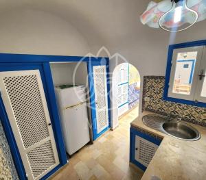 a small kitchen with a refrigerator and a sink at medina hammamet in Hammamet