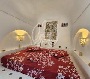 una camera con un letto con copriletto rosso e bianco di medina hammamet a Hammamet