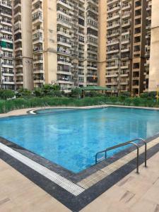 a large swimming pool with tall buildings in the background at Luxury 3 bedroom independent appartment in Ghaziabad